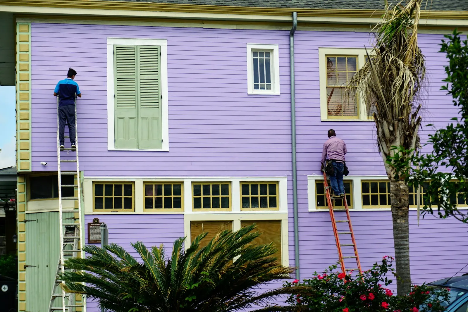 Two Jet Painting decorators working from ladders on a residential exterior in good light